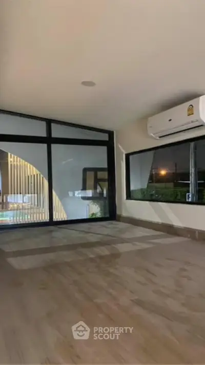 Spacious and modern living area with large windows, natural light, and sleek flooring, perfect for comfortable urban living.