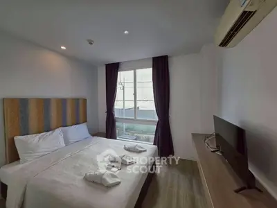 Cozy bedroom with modern decor, featuring a comfortable bed, TV, and air conditioning.