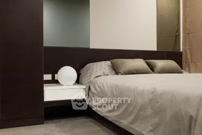 Modern bedroom with sleek design and cozy bedding in a stylish apartment.