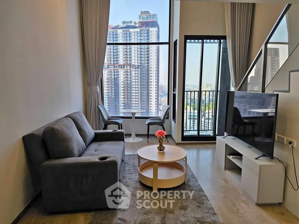 Modern living room with city view, featuring stylish furniture and floor-to-ceiling windows.