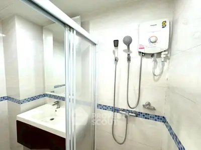 Modern bathroom with shower and sink featuring sleek design and bright lighting.