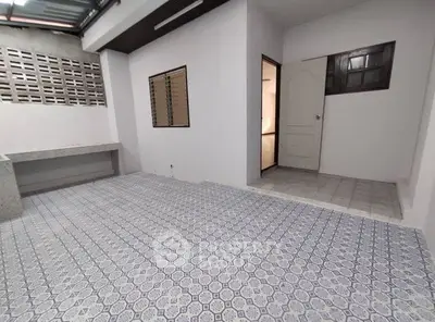 Spacious tiled area with open layout and natural light, perfect for versatile use.