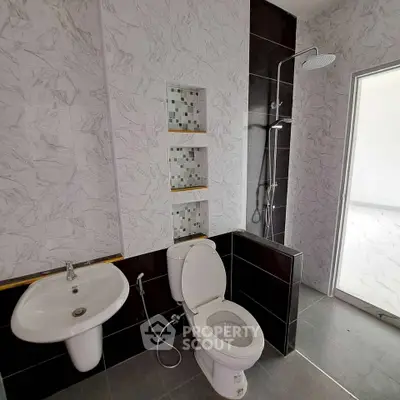 Modern bathroom with sleek design, featuring a rain shower and elegant tile work.