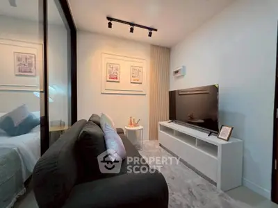 Modern living room with sleek black sofa and wall-mounted TV