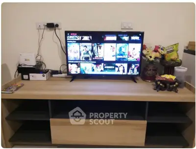 Modern living room with stylish TV setup and wooden entertainment unit.