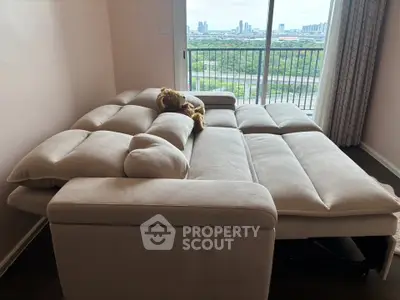 Spacious living room with plush sofa bed and stunning city view from balcony.