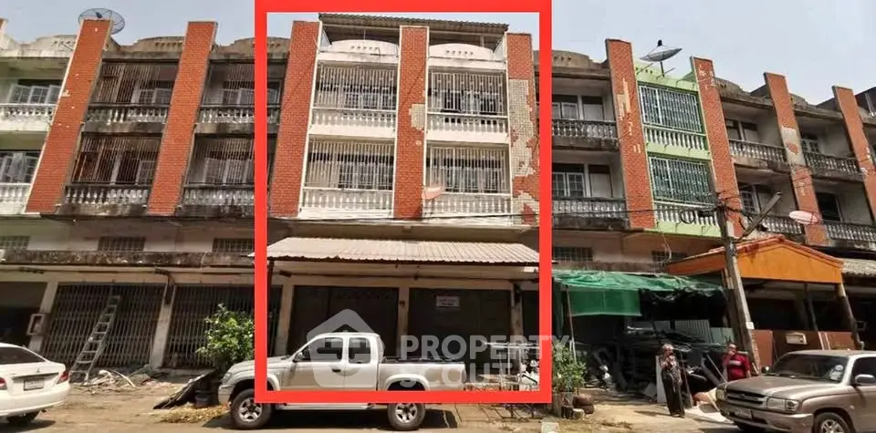 Commercial building with red brick facade and multiple floors, ideal for business opportunities.