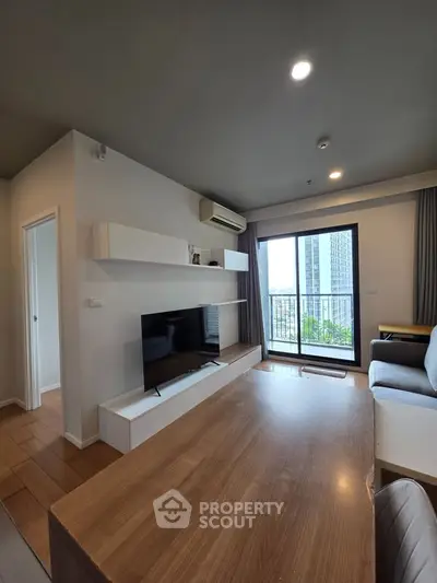 Modern living room with sleek furniture and city view balcony in a stylish apartment.