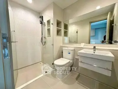 Modern bathroom with sleek fixtures and spacious shower in contemporary apartment.