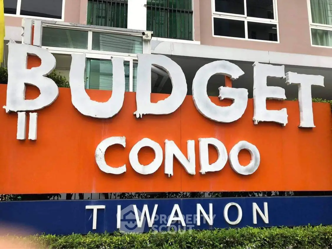 Modern condo building with vibrant signage at Budget Condo Tiwanon.