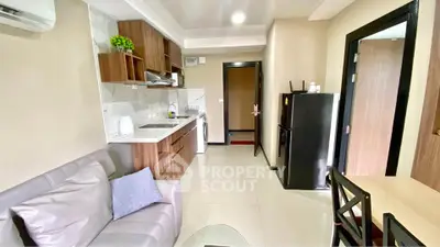 Modern open-layout kitchen and living area with sleek appliances and cozy seating.