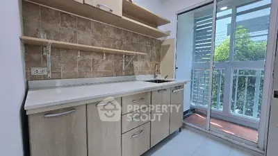 Modern kitchen with sleek cabinetry and large windows for natural light.