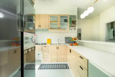 Modern kitchen with sleek cabinetry and gas stove, featuring bright lighting and stylish decor.