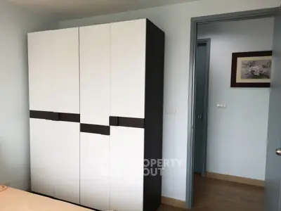 Modern bedroom with sleek wardrobe and wooden flooring