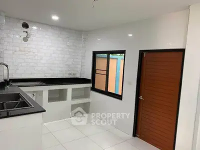 Modern kitchen with sleek black countertops and white tile backsplash