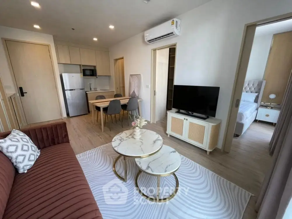 Modern living room with stylish furniture and open kitchen layout in a cozy apartment.