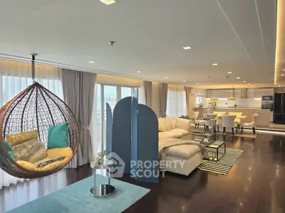 Luxurious open-plan living room with modern decor and hanging chair in upscale apartment.