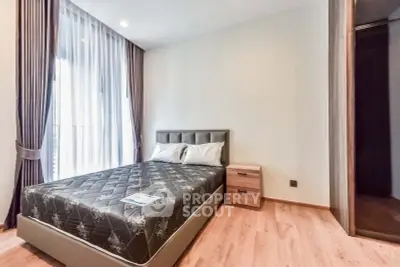 Modern bedroom with stylish decor and natural light, featuring a comfortable bed and elegant curtains.