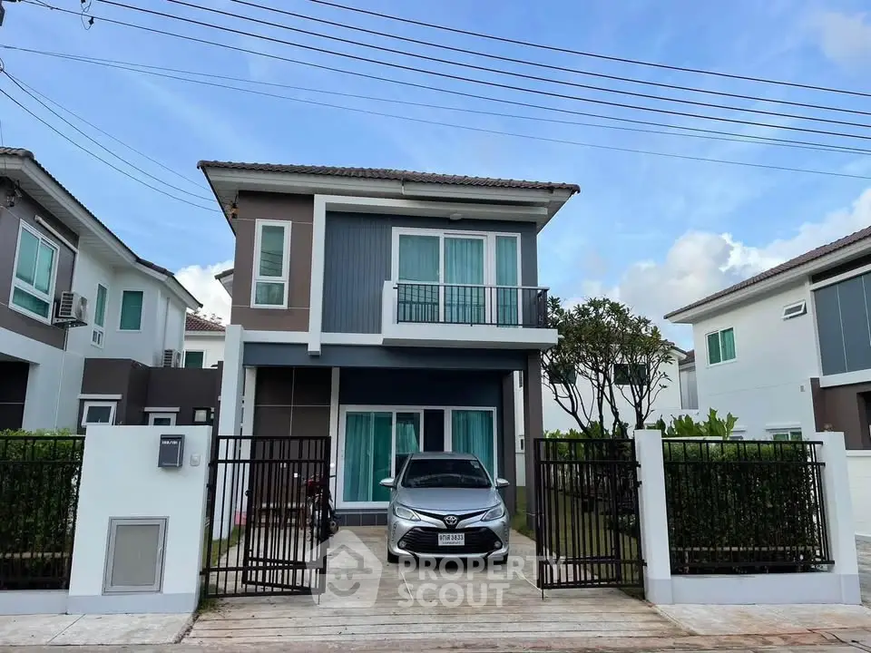Modern two-story house with driveway and car, featuring sleek design and well-maintained exterior.