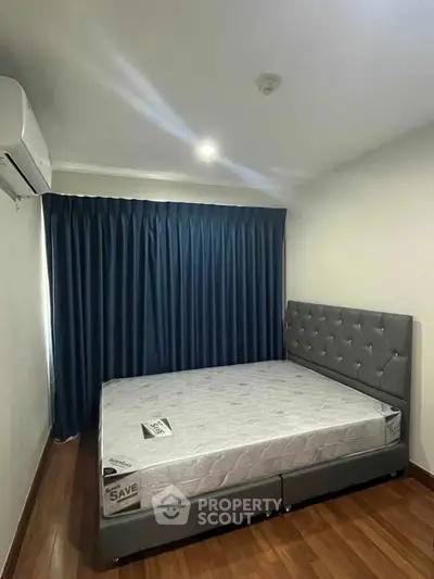 Modern bedroom with elegant blue curtains and stylish grey bed frame.