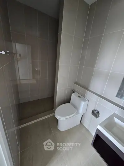 Modern bathroom with sleek tiles and contemporary fixtures in a stylish real estate property.