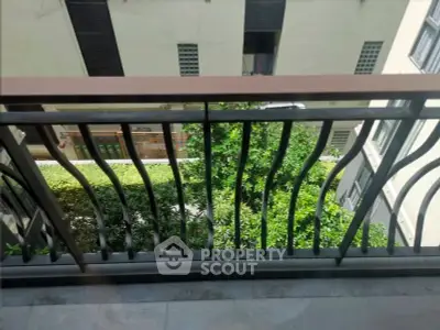 Charming balcony view with lush greenery in a modern apartment complex.