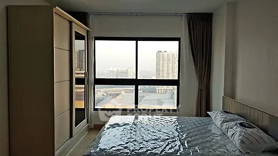 Modern bedroom with large window offering city view and stylish furnishings.