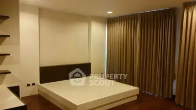 Spacious bedroom with modern design and large windows for natural light.