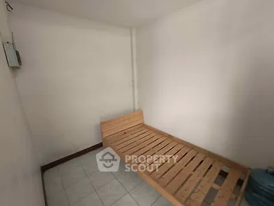 Minimalist room with wooden bed frame and tiled floor, ideal for compact living spaces.