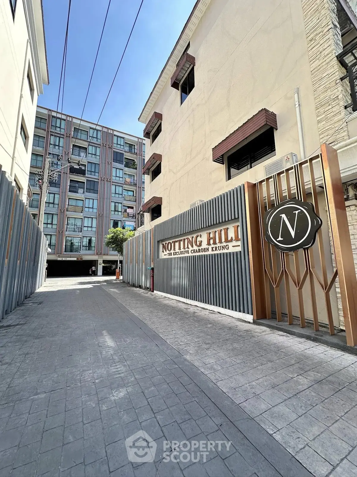 Modern apartment building entrance with stylish gate and Notting Hill sign, showcasing urban living.