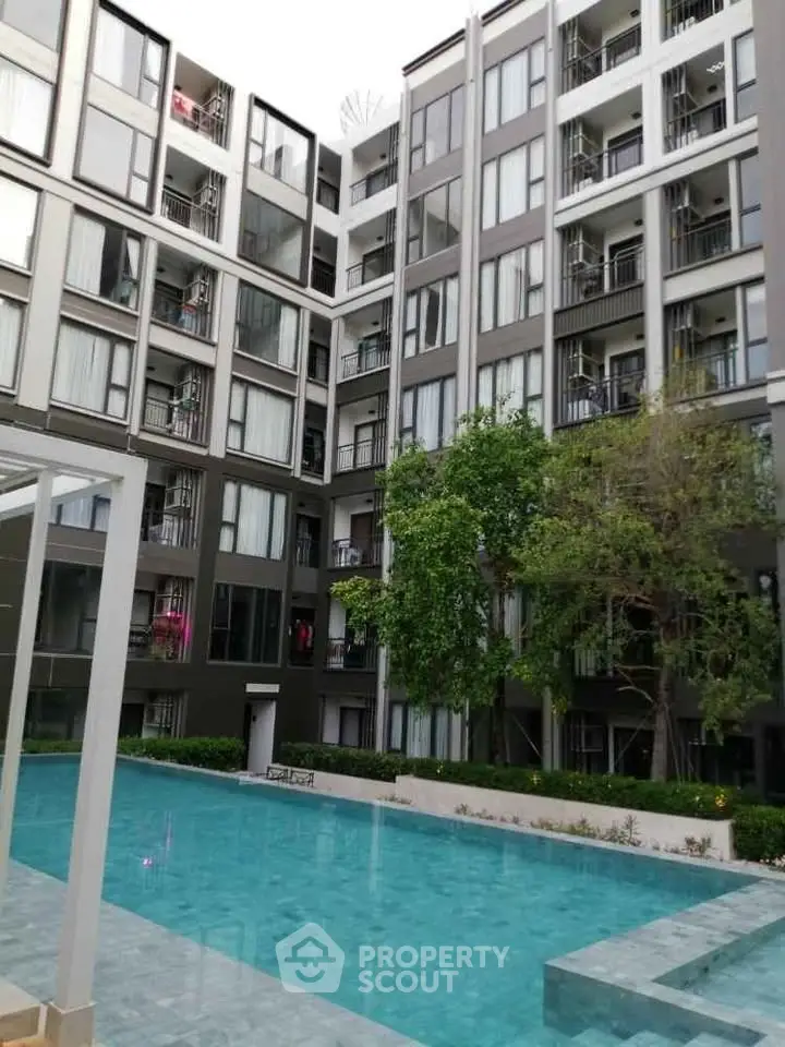 Modern apartment building with pool and lush greenery, perfect for urban living.