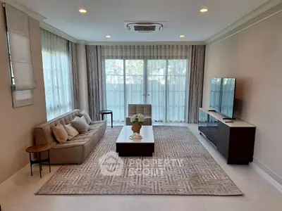 Elegant living room with modern decor, large windows, and stylish furniture