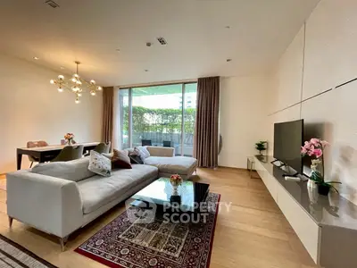 Spacious modern living room with elegant decor and large windows opening to a lush garden view.