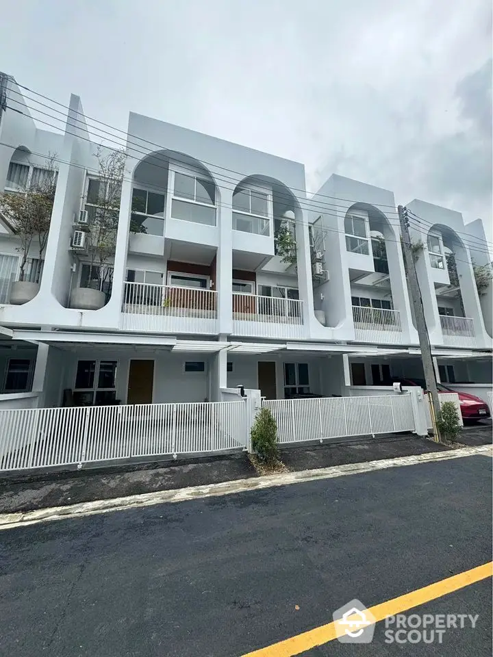 Modern townhouse exterior with unique architectural design and white facade