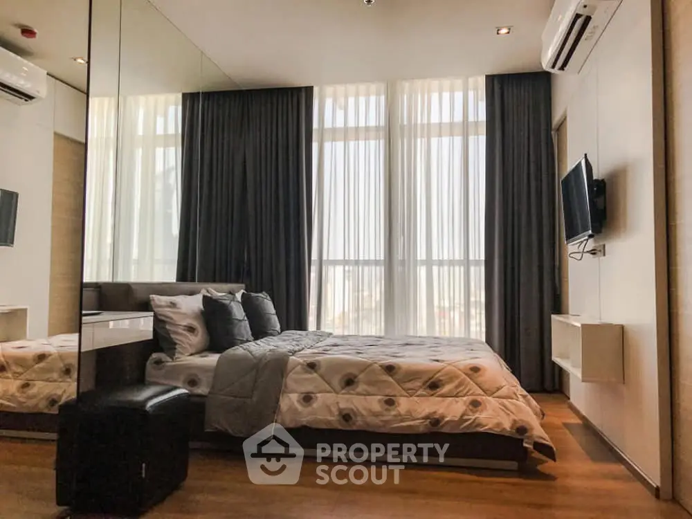 Luxurious bedroom with modern decor, floor-to-ceiling windows, and elegant furnishings.