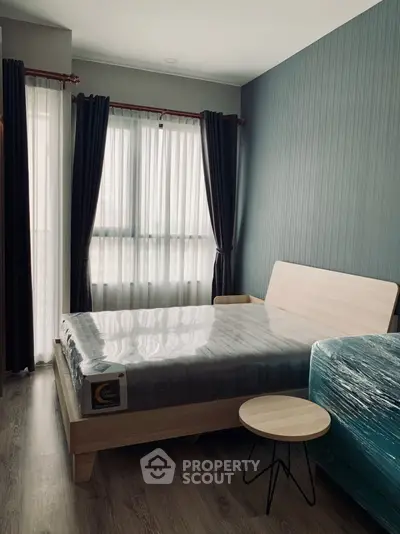 Modern bedroom with sleek design, featuring a stylish bed and natural light through large windows.