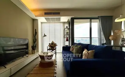 Modern living room with stylish decor and large windows offering city views.