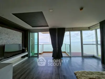 Stunning ocean view from modern living room with floor-to-ceiling windows and sleek flooring.