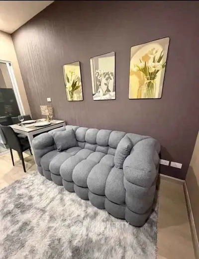 Stylish living room with plush gray sofa and elegant dining area, perfect for modern living.