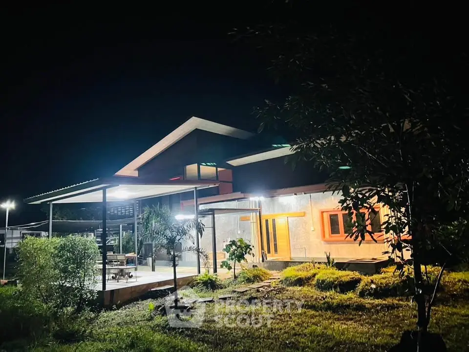 Stunning modern house exterior with night lighting and lush garden