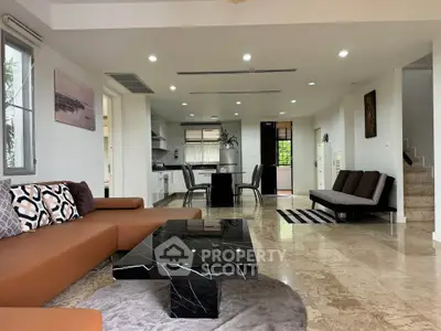 Spacious open-plan living room with modern furnishings and marble flooring