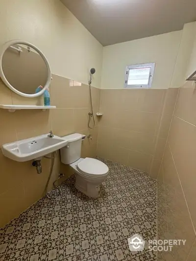 Compact bathroom with modern fixtures and stylish patterned floor tiles.