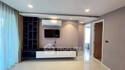 Modern living room with sleek TV unit and air conditioning in a stylish apartment.