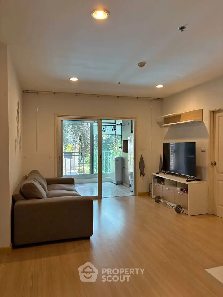 Spacious living room with modern decor and large sliding doors leading to a balcony with a view.