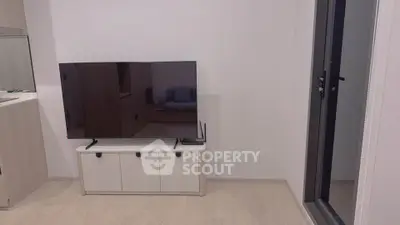Modern living room with sleek TV setup and balcony access