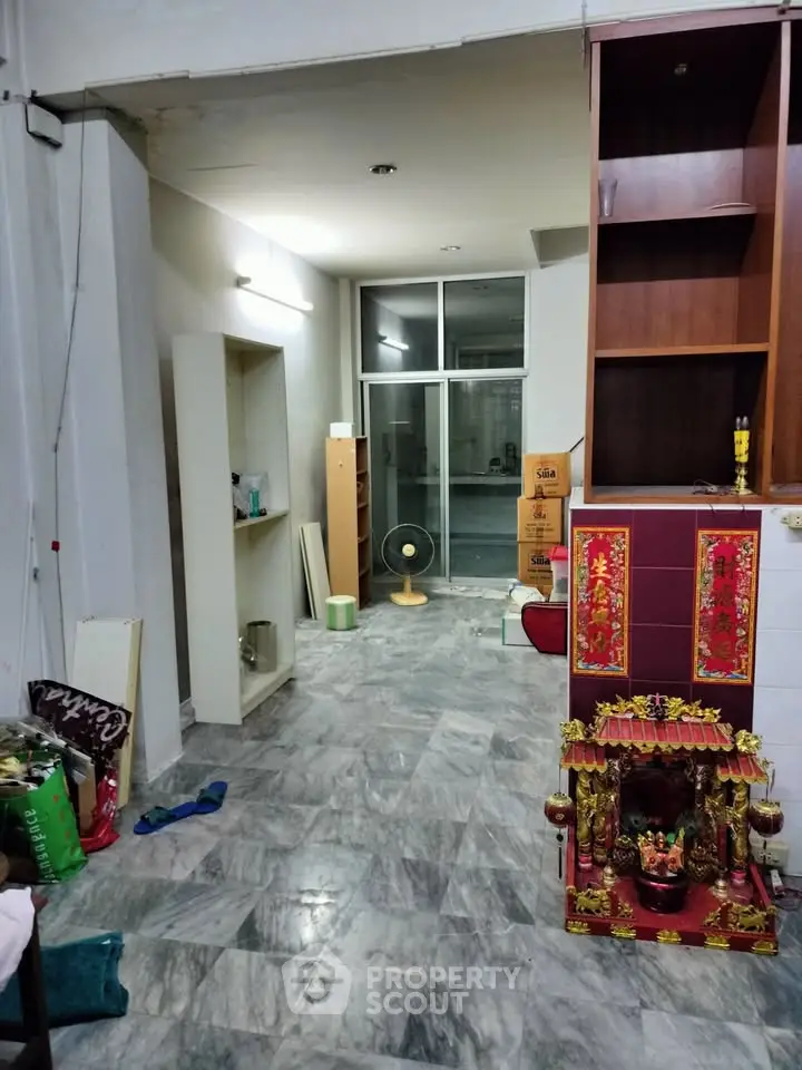 Spacious interior with marble flooring and built-in shelves, ideal for versatile living space.