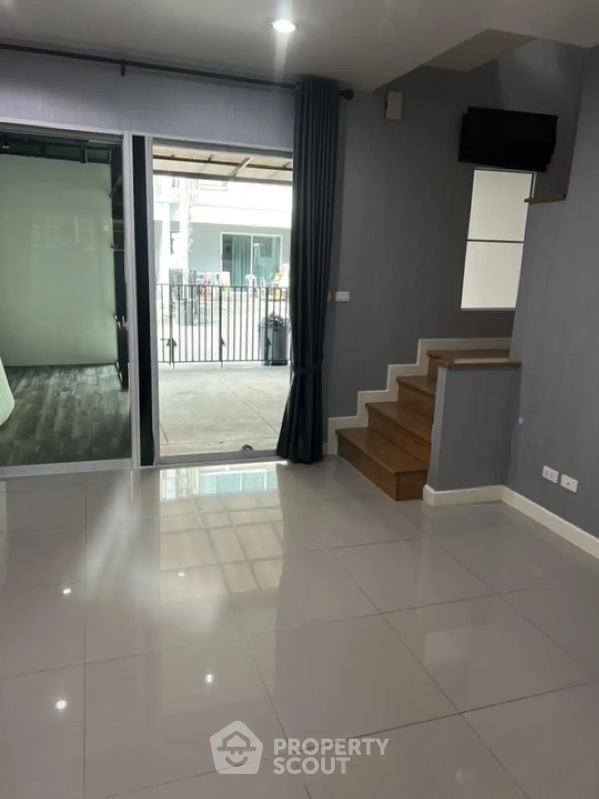 Modern interior with sleek tiled flooring and staircase, ideal for contemporary living.