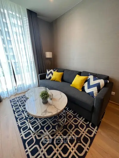 Modern living room with stylish sofa, decorative pillows, and elegant coffee table in a bright apartment.