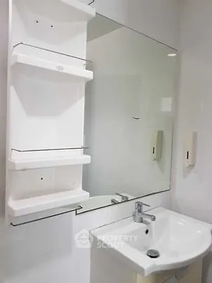 Modern bathroom with sleek sink and mirror, featuring white shelving for storage.