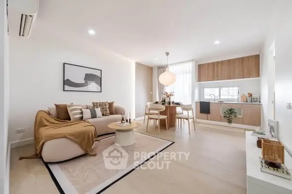 Modern open-plan living room with stylish decor and kitchen area